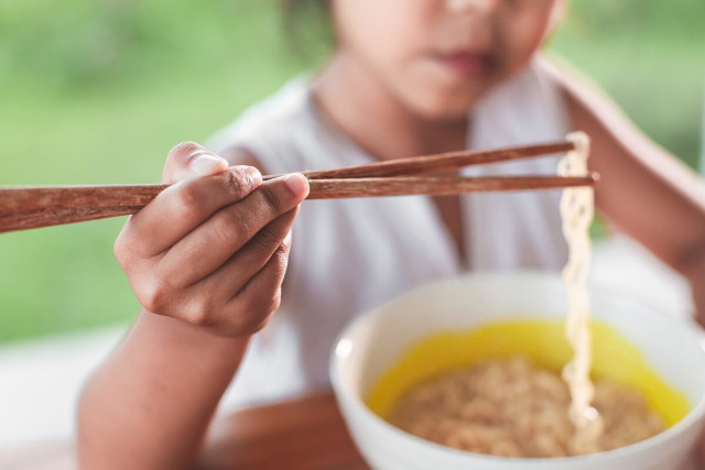 子どもが箸で麺をとる